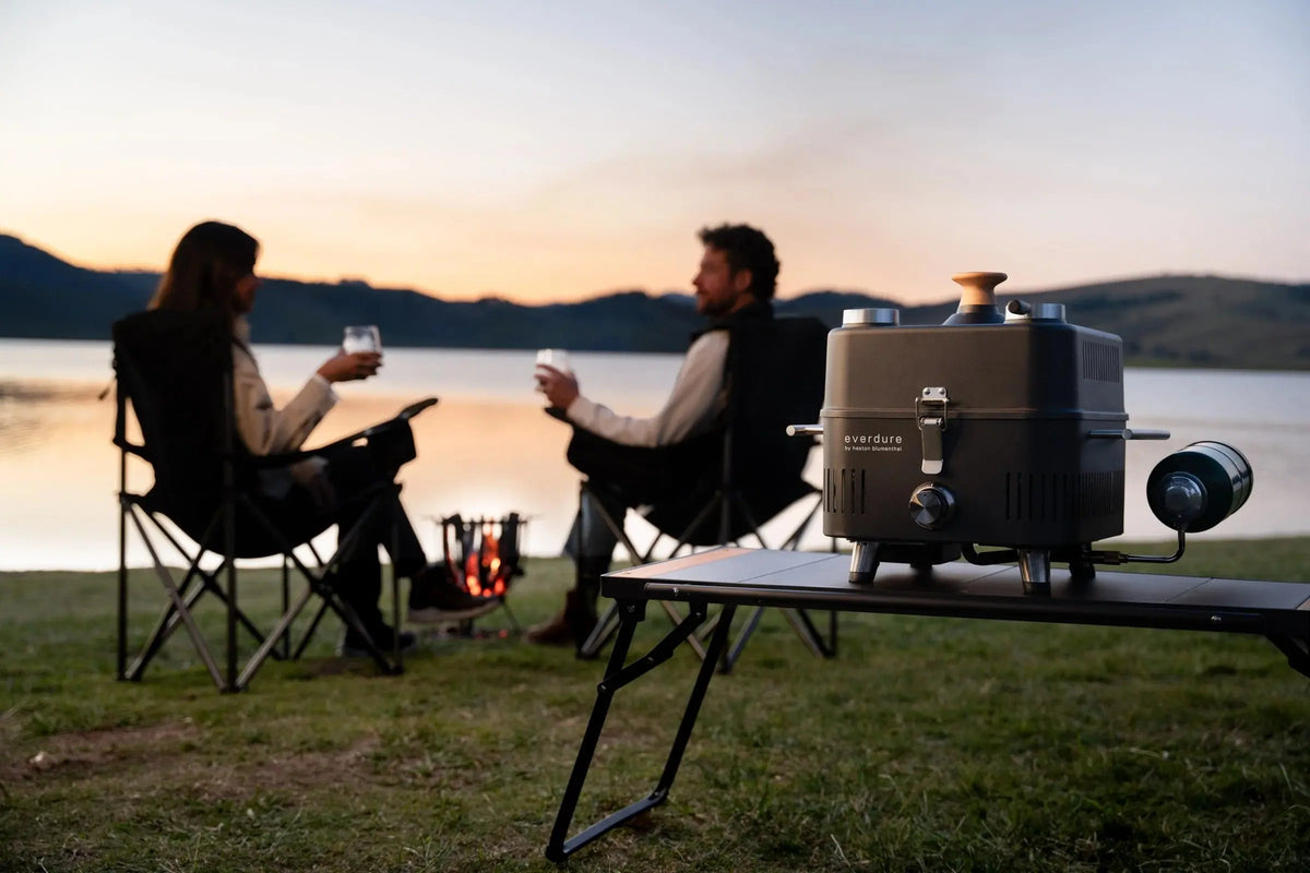 Modern outdoor kitchen featuring Everdure Hub II grill with stainless rotisserie and sleek charcoal finish